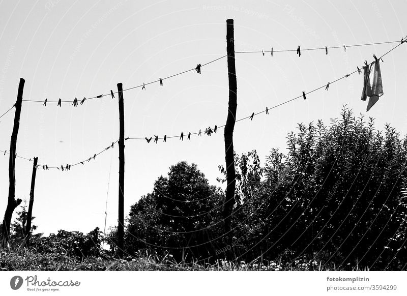 Clothesline with clothespins and posts as a black and white silhouette against the sky Clothes peg Laundry Washing day Dry Clean Pole Household