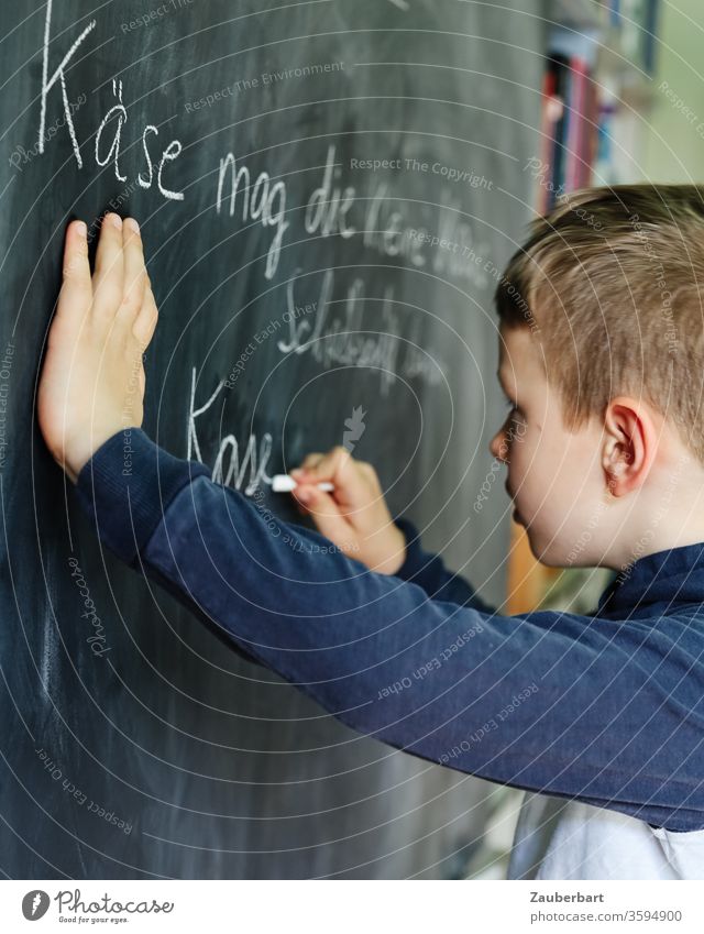 Homeschooling V - Boy writes with chalk on a blackboard a practice set for cursive writing School Boy (child) pupil schuler Elementary school Blackboard Chalk