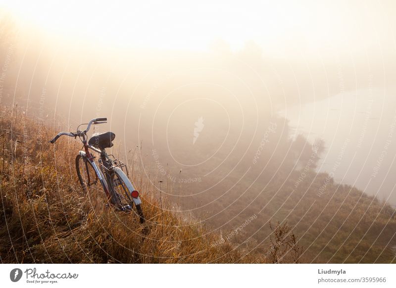 An old bicycle early in the morning in countryside and landscape mist.  Bicycle travel concept. Space for text male speed man active trail extreme action sport