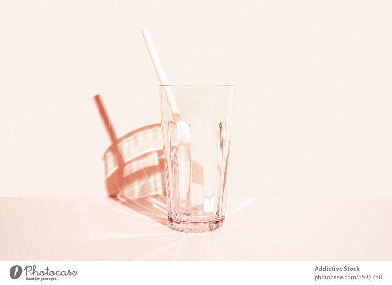 Empty glass with straw in studio empty glassware crystal drink beverage refreshment transparent cold plastic summer serve creative simple minimal shadow shiny
