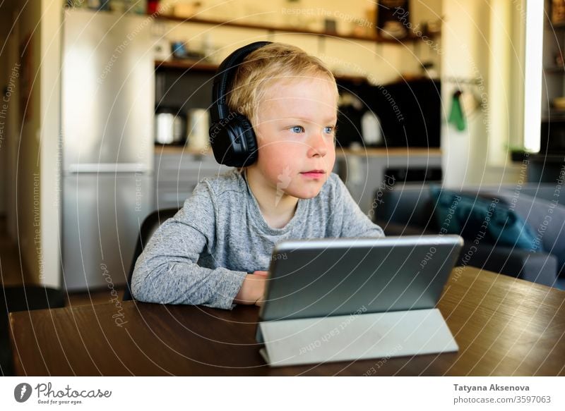 Cute little boy home schooling studying with his gadget laptop