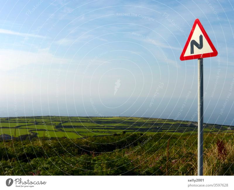 curving down to the sea... traffic sign curvy Curve street sign Clue Signage Pole Landscape England Cornwall hillock Field Hedge Beautiful weather Nature Ocean