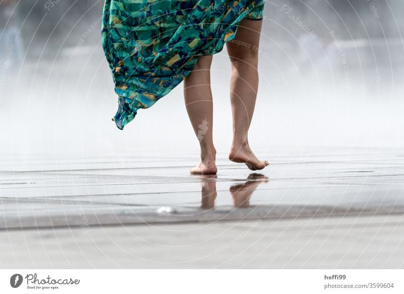 the young woman walks barefoot over a wet surface - the spray of the Miroir d'eau provides a welcome cool-down Barefoot feet Legs leg Wet Toes Skin Water Shadow