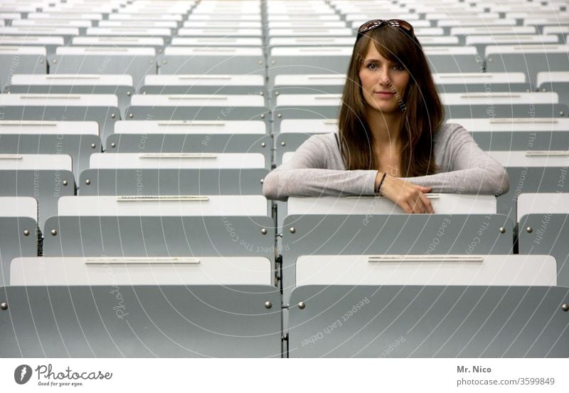 young woman sitting in the second row spectator seats Audience Event Seating Places Empty tribune Row Row of seats Side by side Structures and shapes boardroom
