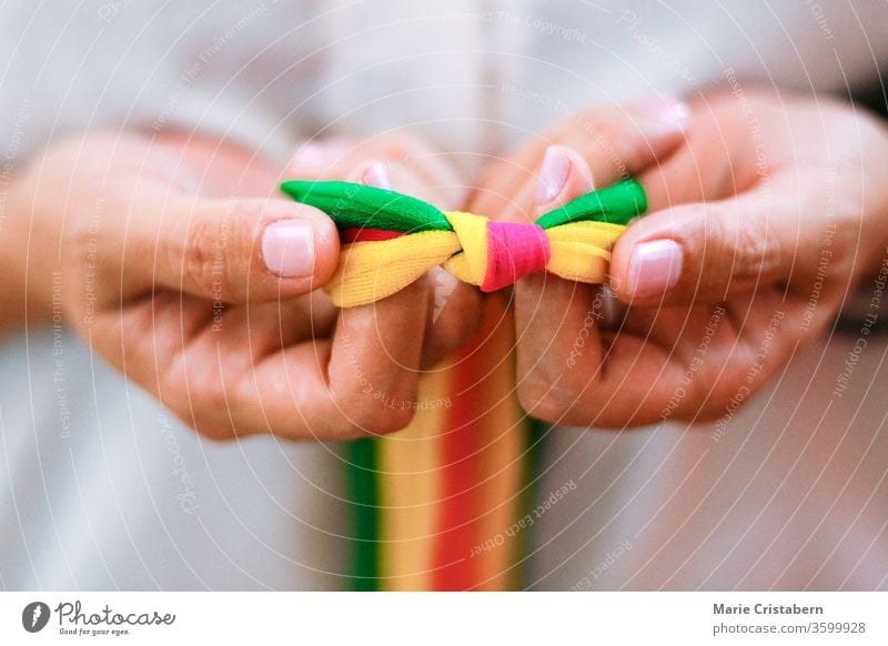 Hands holding rainbow colored ribbons in celebration of Pride Day, diveristy, equality and the LGBTQ community pride day Pride concept Pride colors lgbtq+