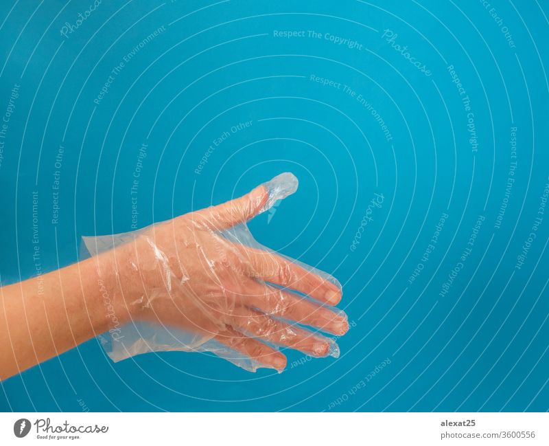 Hand with plastic glove before handshake on blue background with arm body care clean closeup clothing copy space covid-19 disposable equipment finger flu gloves