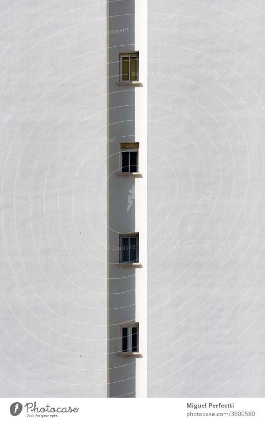 Detail of a building, where only a row of small windows is seen vertically facade apartment architecture tower skyscraper urbanization construction glass white