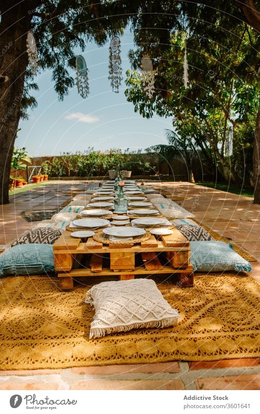 Wooden pallets and cushions on terrace for party summer celebrate banquet sunny event wooden simple furniture cozy shape table holiday design comfort style