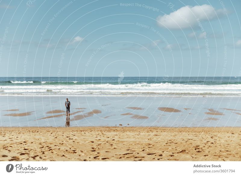 Unrecognizable tourist standing on sand sea beach under blue sky footprint shoreline spectacular harmony idyllic seascape horizon scenery nature wave