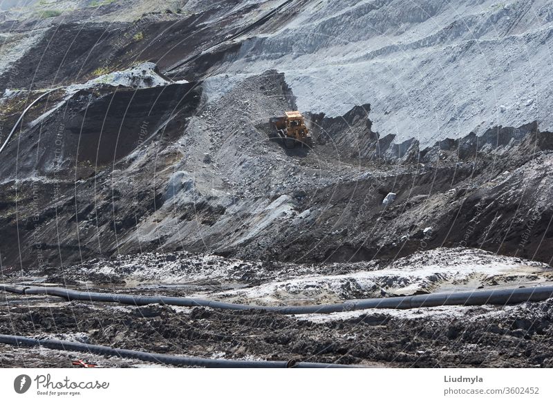 A bulldozer working in a quarry outdoors unloading ground wheel track build earthmoving mountain manufacturing mineral development quarrying technology