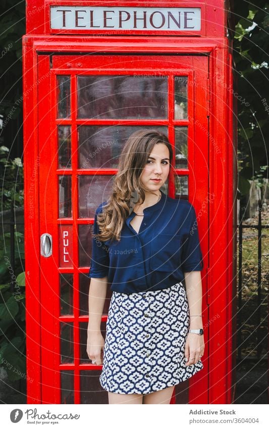 Charming woman near red telephone box on street telephone booth charming city old fashioned tradition retro culture female london england uk united kingdom