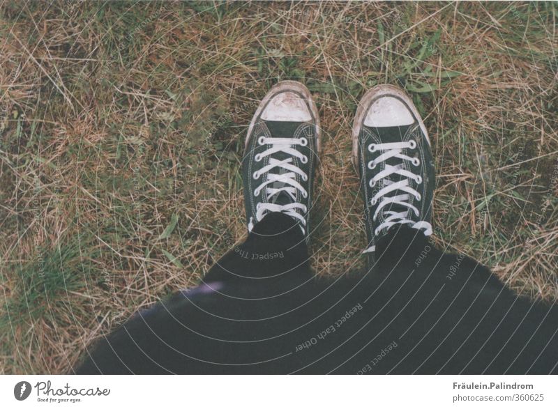 A girl with colorful striped stockings stands on the shadow of a