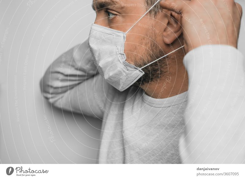 A man puts a medical mask on his face coronavirus quarantine covid-19 health communication protection corona virus protective mask concentration homey