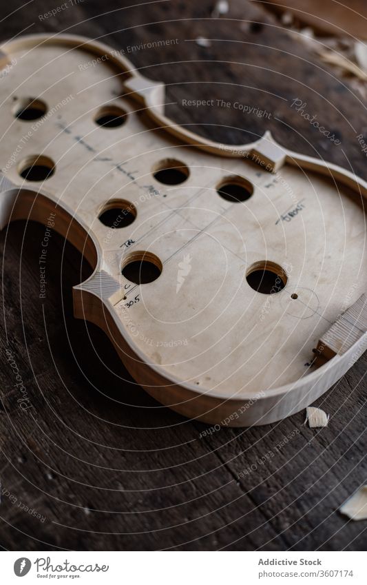 Soundboard of handmade violin on shabby wooden surface in workroom soundboard process workshop hole tool craft sawdust instrument workmanship create detail