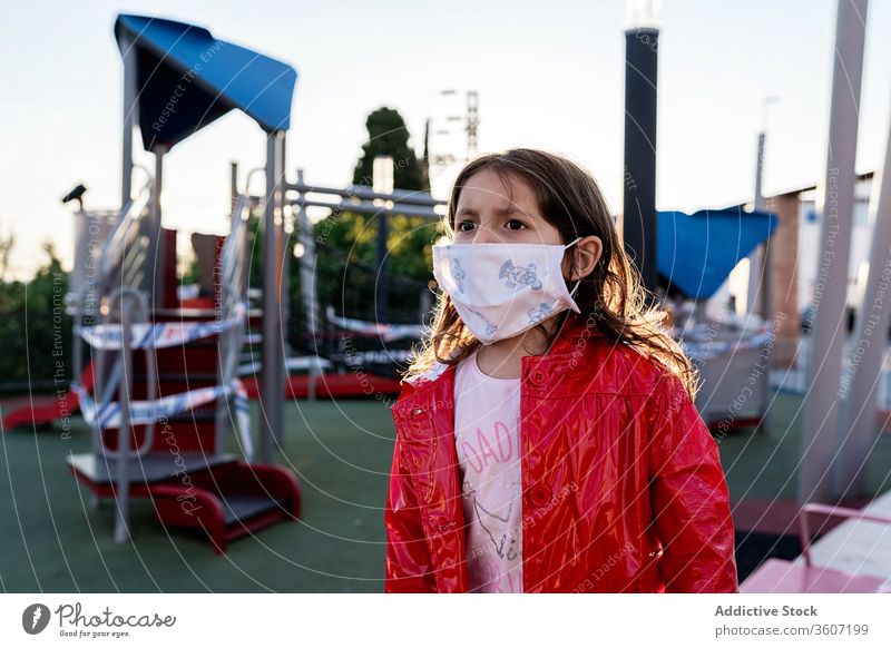 Frowned girl in medical mask on playground child worried outbreak coronavirus frown city ethnic kid childhood modern urban street upset unhappy disappoint