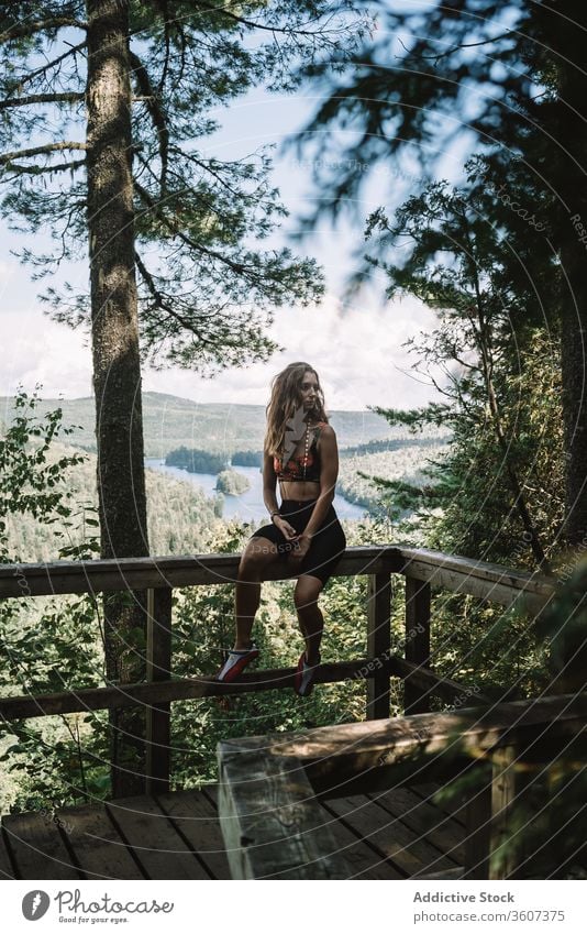 Woman resting on terrace in forest woman nature railing sit summer national park la mauricie quebec canada female travel tourist wooden relax tree vacation