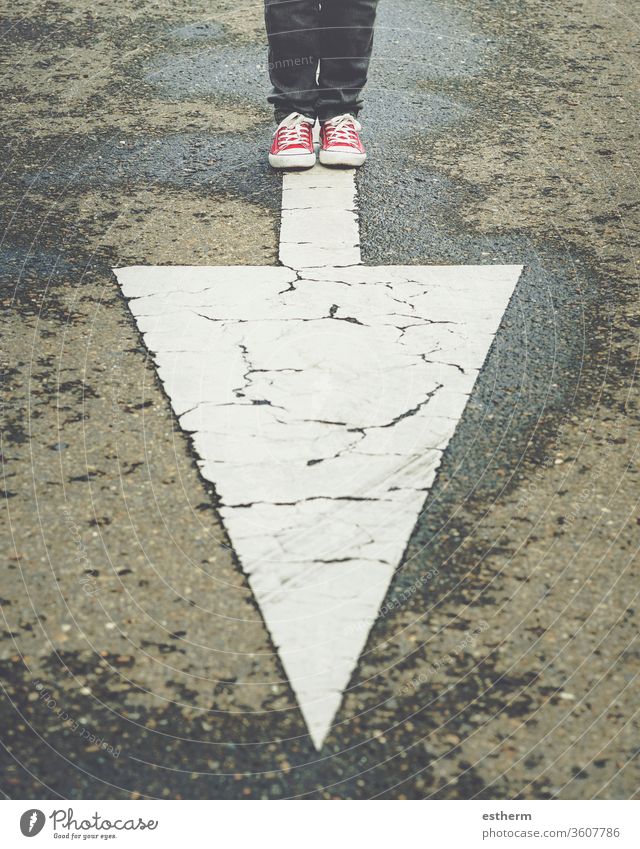 sneakers near the arrow marking of the road trendy foot people route traveler direction adventure explore footwear sign single course casual style modern