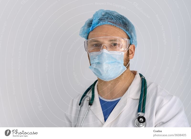 Portrait of a doctor with face mask and protective glasses portrait looking tired eyes facemask stethoscope hospital man covid19 coronavirus healthcare medical