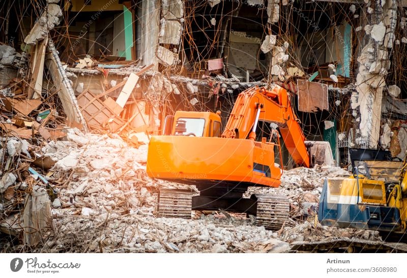Destroyed building industrial. Building demolition by explosion. Abandoned concrete building with rubble and scrap. Earthquake ruin. Damaged or collapsed building from hurricane disaster. Backhoe.