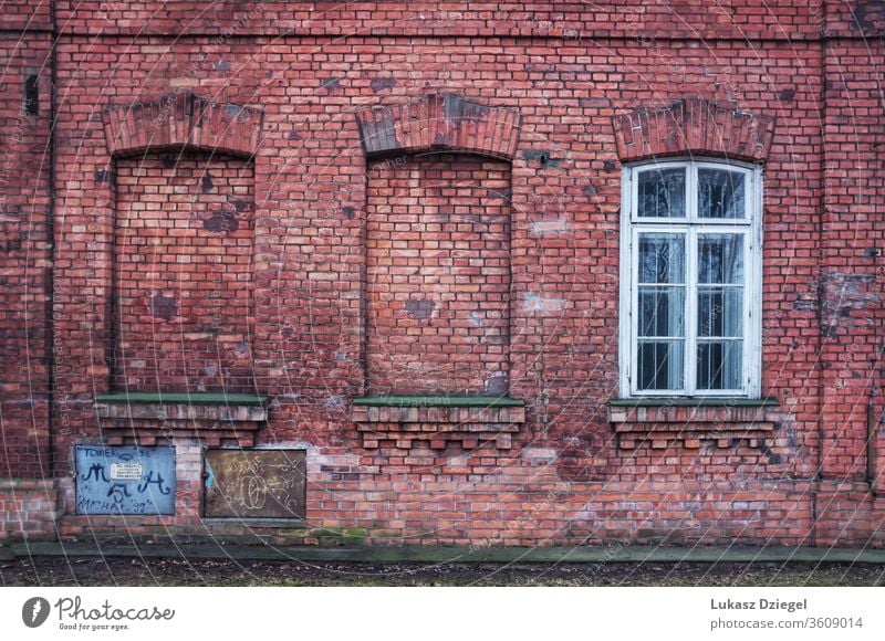 The red brick wall with three window openings, two of which have been bricked up material wall with window dilapidated vintage rust rustic retro outdoor loft