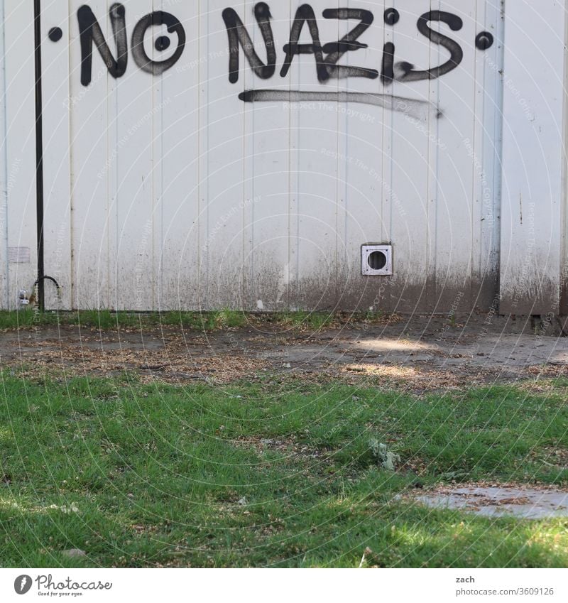 Message "no Nazis" on a white wall Graffiti Facade Wall (building) Characters built Letters (alphabet) Wall (barrier) lettering Gray Politics and state