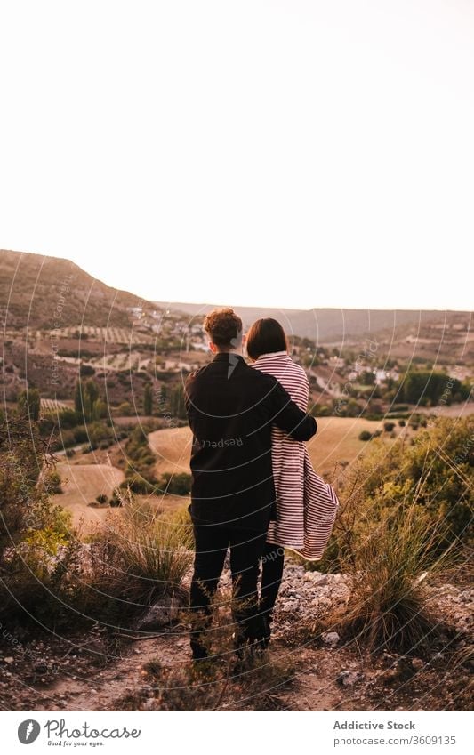 Gentle couple embracing on hill during vacation hug valley admire mountain together spectacular scenery girlfriend boyfriend plaid relationship nature love
