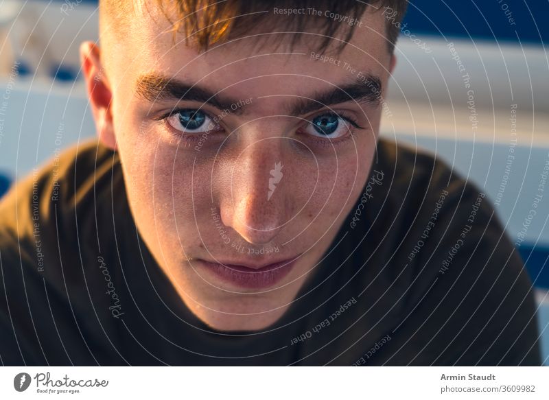 close up portrait of a smiling young man adolescent background beautiful boy candid casual caucasian closeup confident cool cropped dark evening eyes facade