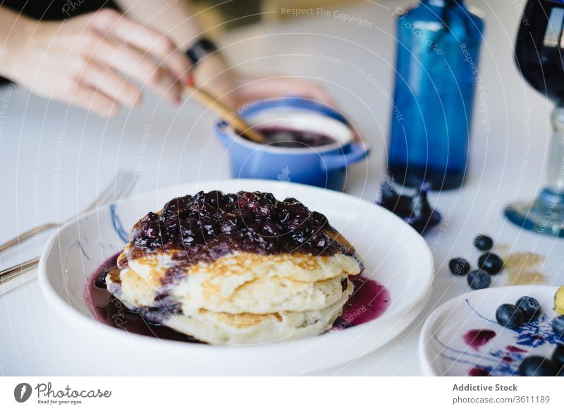 Woman serving delicious brunch with pancakes breakfast jam blueberry homemade woman serve food yummy morning female hand cozy table tasty meal fresh sweet