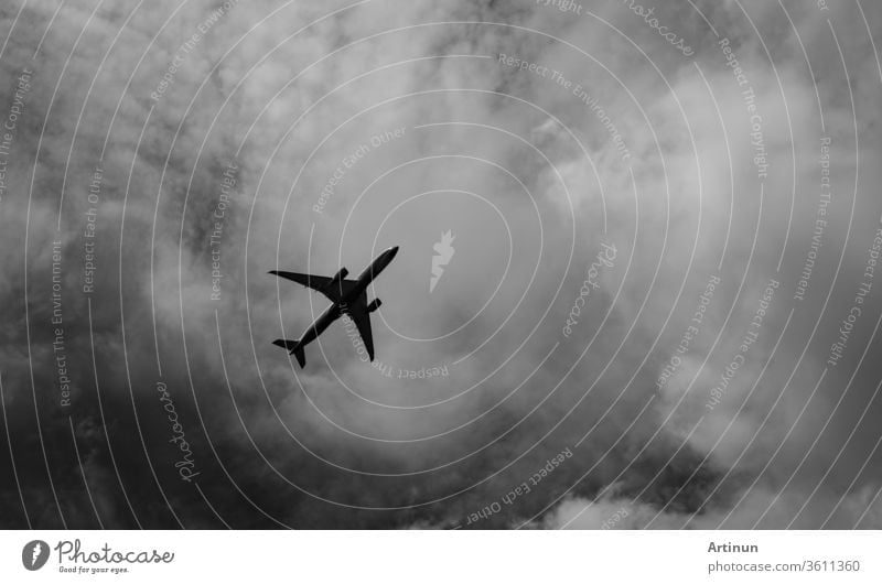 Commercial airplane on grey sky and clouds with copy space. Failed vacation. Hopeless and despair concept. Moody sky and transport plane. Sad emotional scene. Background of aircraft flight.