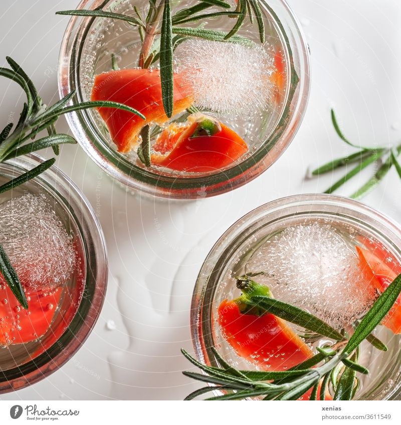Three glasses of piquant cold soft drink with red pepper, rosemary and ice cubes Beverage Cold drink Pepper Rosemary Ice cube three vitamins Refreshment spicy