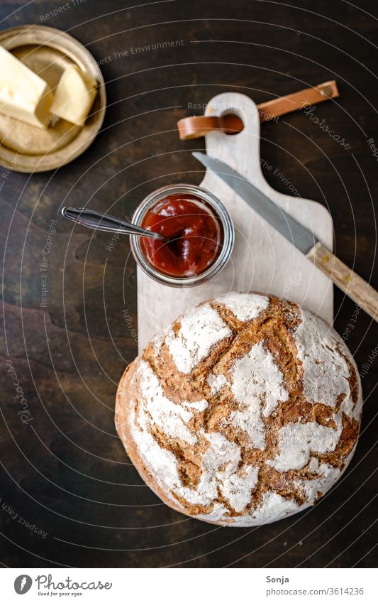 A loaf of bread, a glass of jam and butter on a golden plate, rustic style Bread Jam Butter Breakfast Plate Chopping board plan Food baked Delicious Sweet Fresh