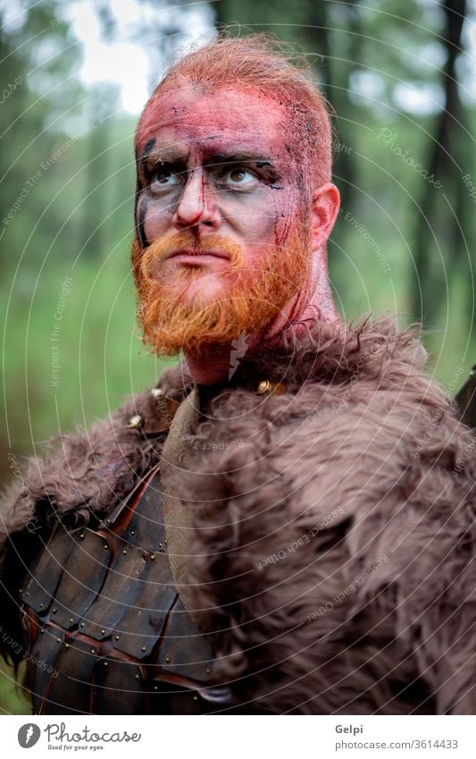 Real viking with many trees around warrior scandinavian ancient aggression portrait historical armor history traditional expression culture furious terrified