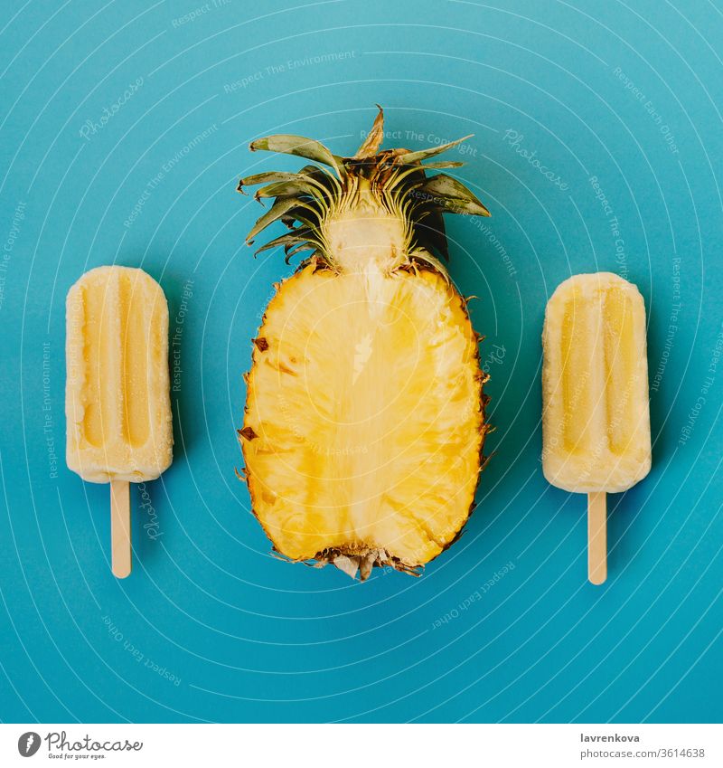 Tropical flat lay of three vegan popsicle and half of ripe pineapple on cyan background seasonal summer cold dessert food cut flatlay diet ice cream tasty