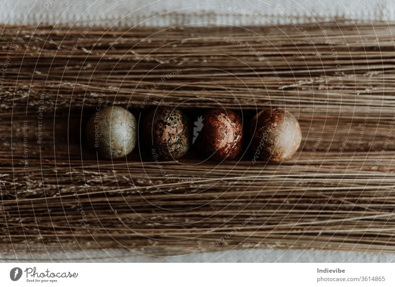 Four different pattern natural dyed egg easter decoration on straw background on a linen tablecloth organic concept top view seasonal tradition homemade nature