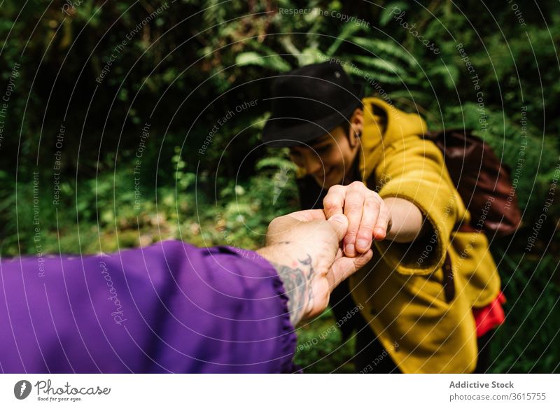 Couple of travelers together in forest help hand trekking couple offer support holding hands gesture relationship asturias spain vacation woods green girlfriend