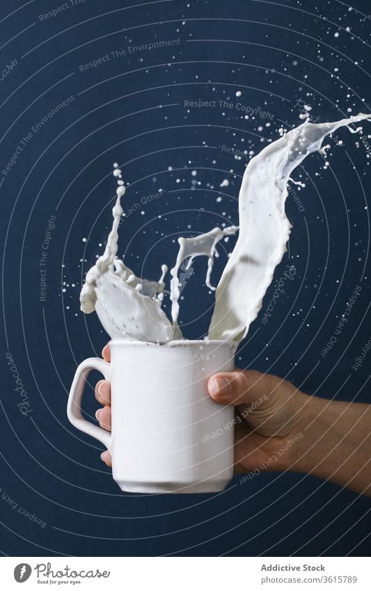 Woman with cup of splashing milk - a Royalty Free Stock Photo from