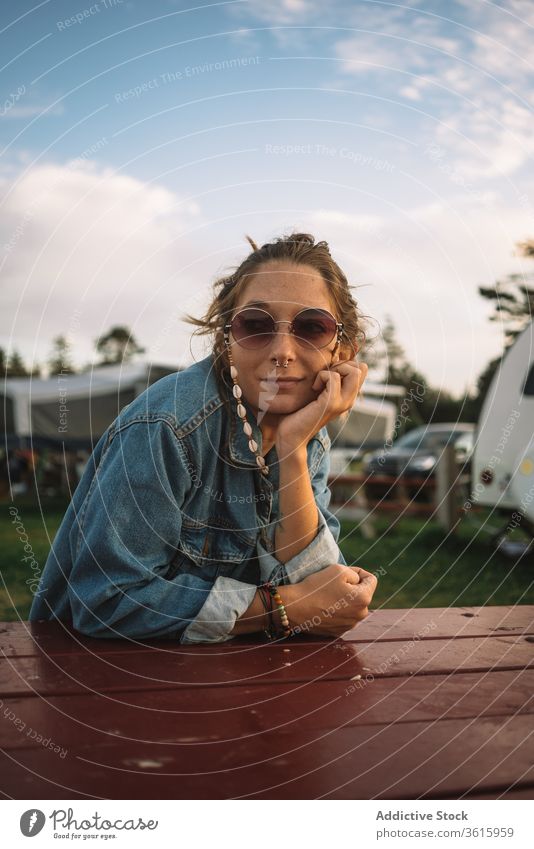 Woman relaxing in camping area hippie campsite woman travel sunset peaceful summer vacation female calm wooden table rest holiday camper tranquil serene enjoy