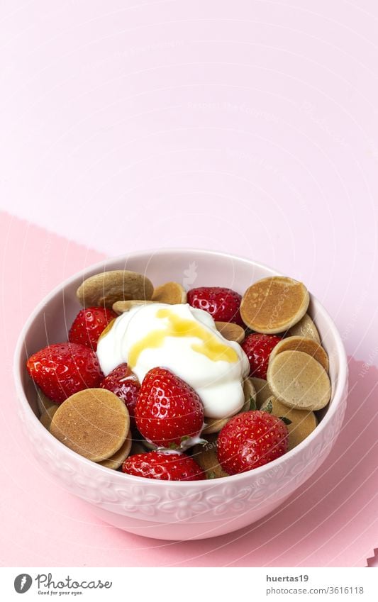 Homemade cereals mini pancake with yogurt, honey and strawberries on colorful background. homemade pankakes delicious food dessert vegan food healthy tasty