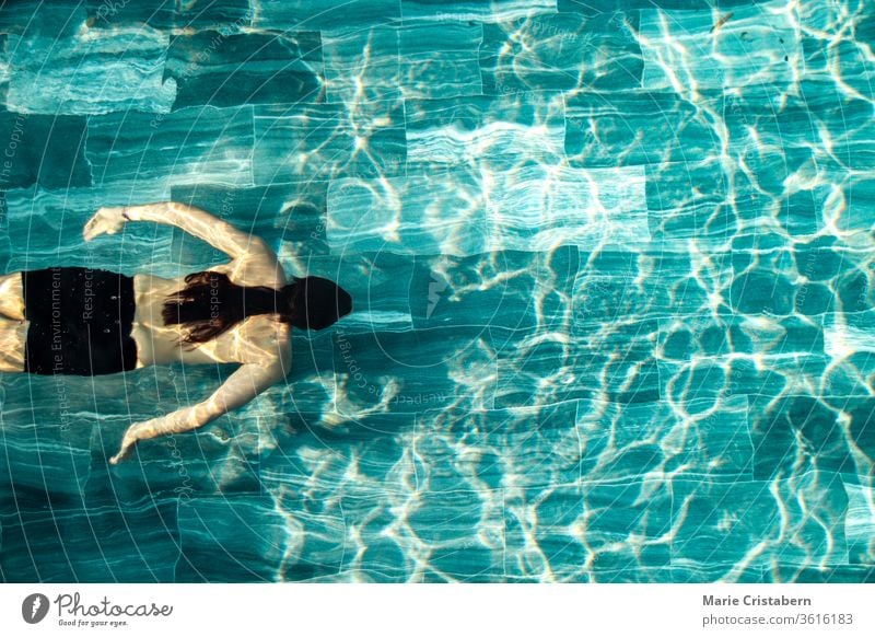 A man swimming alone in the pool showing the concept of staying fit in the new normal lifestyle due to the covid-19 pandemic social distancing