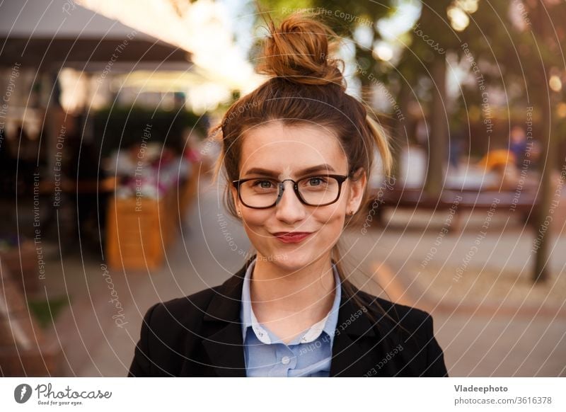 Young caucasian businesswoman in glasses smiling pursed lips. suit happy person portrait female young beautiful outdoor girl cute fashion pretty happiness