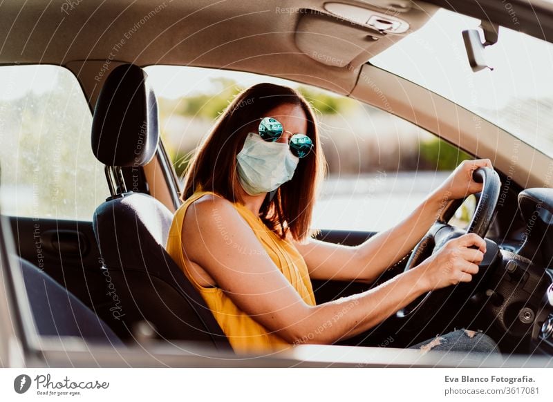 young woman in a car with a protective mask. Summer season. Concept for the prevention of the coronavirus Woman Car Face mask Virus pandemic Corona virus COVID