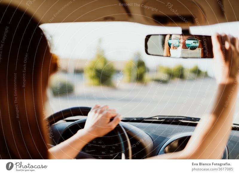 young woman in a car wearing protective mask. Summer season. prevention corona virus concept pandemic covid driving driver travel summer sunset trip adult
