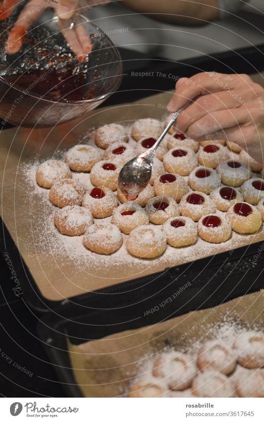 Christmas bakery: Filling a woman's hands with a teaspoon of currant jelly in angel's eyes, also called hussar doughnuts | Anticipation Cookie Christmas baking