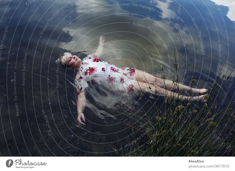 Portrait of a young blonde woman in a white summer dress in a lake on the surface girl Young woman already Blonde long hairs youthful 19 18-20 years