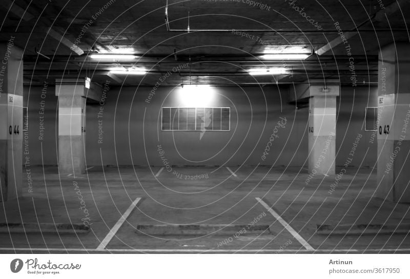 Perspective view of empty indoor car parking lot at the mall. Underground concrete parking lot with open light. Feel sad and lonely concept. Q43 and Q44 car parking lot at B2 block