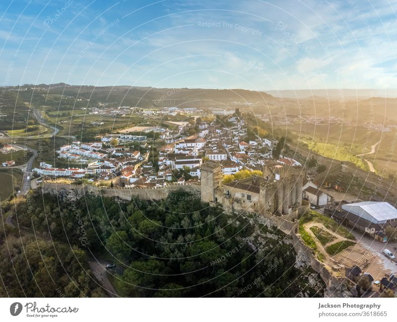 Aerial shoot of Obidos with historic walls and castle, Portugal obidos aerial portugal leiria myth fairy tale green sky yellow copy space sunset