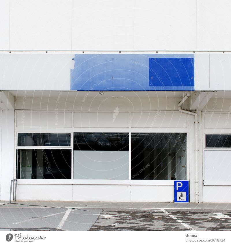 façade Facade Window White Blue Parking lot Signs and labeling Parapets Commerce Vacancy Gloomy dreariness Exterior shot Deserted Building Manmade structures