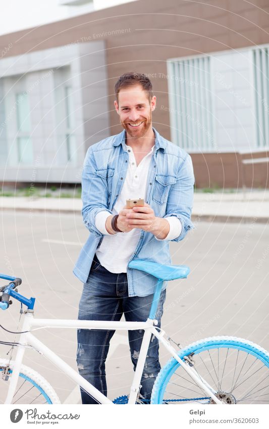 Casual guy next to a vintage bicycle with the mobile wearing denim shirt phone young man urban lifestyle office business businessman person male city outdoors