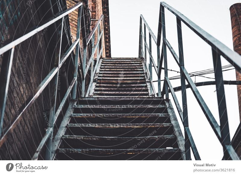 Exterior rusty stairs of an old abandoned textile factory building stairway shabby metallic brick exterior weathered aged structure industrial construction