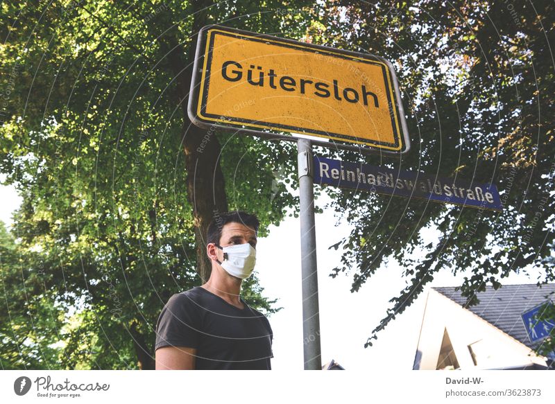 Man with breathing mask in Gütersloh - place-name sign - Corona / covid19 Rheda-Wiedenbrück Oelde cordon keep sb./sth. apart gap Safety covid-19 Tönnies